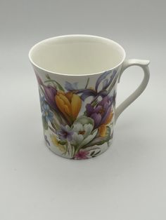 a coffee cup with flowers painted on the outside and inside, sitting on a white surface