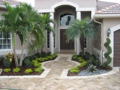 a house with palm trees and landscaping in front of the entrance to the home is shown