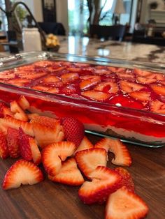 sliced strawberries sit in front of a dessert dish