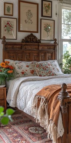 a bed sitting in the middle of a bedroom with pictures on the wall above it