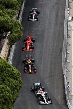 a group of cars driving down a race track