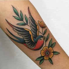 a tattoo with a bird and flowers on it's arm, done by kalli tattoo studio