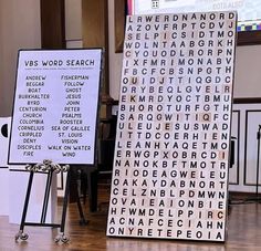 two signs with words on them in front of a projector screen that says word search