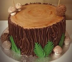 there is a cake that looks like a tree stump with pine cones and leaves on top