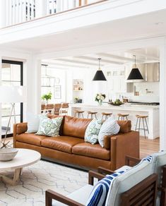 a living room filled with furniture next to a white stair case in a home on top of a hard wood floor