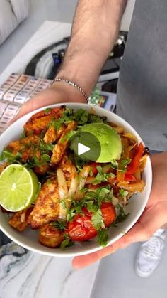 a person holding a white bowl filled with food