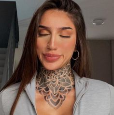 a woman with her eyes closed wearing a neck tattoo