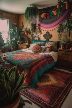 a bed with colorful blankets and pillows in a room filled with potted greenery