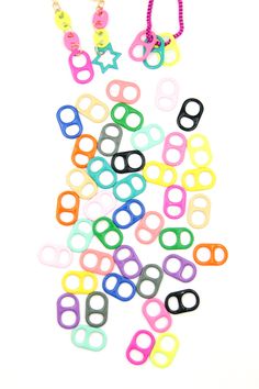 a pile of multicolored bracelets and necklaces on a white background with space for text