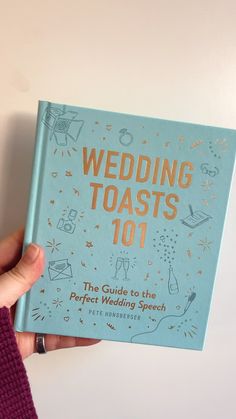 a person holding up a wedding toast book