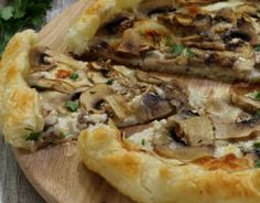 a mushroom and cheese pizza on a wooden cutting board