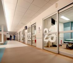 an empty hospital hallway with glass doors and medical equipment on the floor in front of them