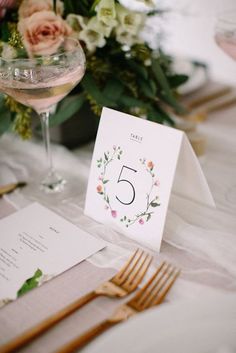 the table is set with silverware and flowers