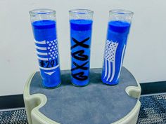 three blue candles sitting on top of a round table with an american flag painted on it