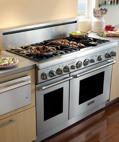 a stove top oven sitting inside of a kitchen next to a counter with food on it