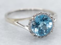 This white gold ring is a sparkling dream with its round cut blue topaz and diamond halo. Shine bright and stand out from the crowd with this unique and stunning piece of jewelry. Perfect for every occasion, it will add a touch of glamour to any outfit. Metal: 14K White Gold Gem: Blue Topaz 1.00 Carats Gem Measurements: 7.0 mm, Round Accents: 18 Diamonds totaling .08 Carats, SI-I in Clarity, H-I in Color Ring Size: 6 Marks: "14K 585" Stamped on the inside band SKU #: A40769 Each piece has been i Diamond Halo Ring, Ring With Diamond, Watch Chain, Halo Diamond Ring, Ring Diamond, Color Ring, Blue Topaz Ring, Halo Ring, Diamond Halo