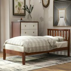 a bed sitting on top of a wooden floor next to a dresser