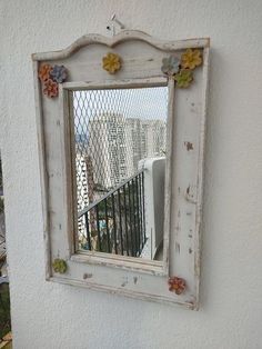 an old mirror hanging on the side of a building