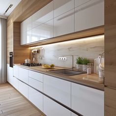 a kitchen with white cabinets and wooden counter tops next to a sliding glass door that leads out onto a balcony