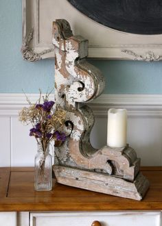 a vase with flowers sitting on top of a wooden table next to a framed photo