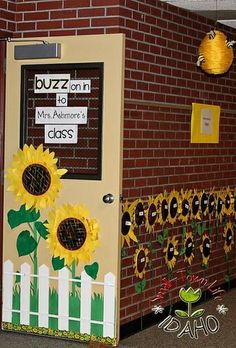 a door decorated with sunflowers and paper mache on the side of a brick building