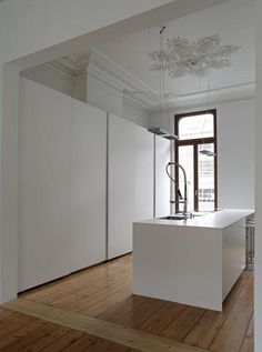 an empty kitchen with white walls and wooden floors