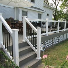 a deck with an umbrella over it in front of a house