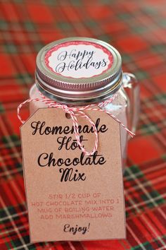 homemade hot chocolate mix in a glass jar on a plaid tablecloth with a tag