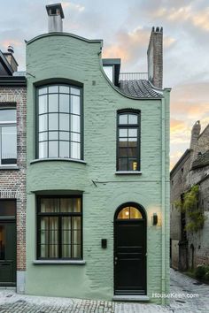 a green house with black doors and windows