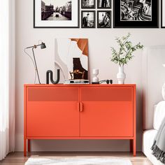 an orange cabinet with pictures on the wall