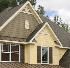 a house with brown shingles and white windows