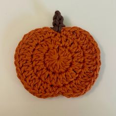 an orange crocheted pumpkin sitting on top of a table