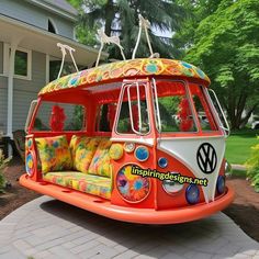 an orange and white vw bus is parked in front of a house