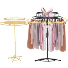 a rack with clothes on it next to a round metal stand and a circular yellow table