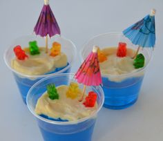 three plastic cups filled with ice cream and colorful umbrellas on top of each cup