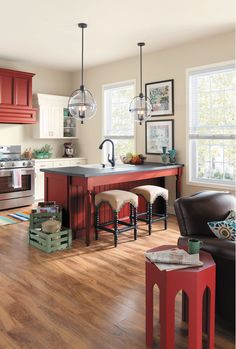 a kitchen with red cabinets and wooden floors