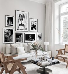 a living room filled with white furniture and pictures on the wall above it's coffee table