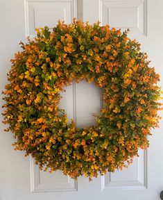 an orange wreath hangs on the front door