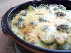 a casserole dish with broccoli and cheese in it on a table