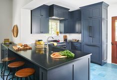 an image of a kitchen setting with blue cabinets and counter tops, along with stools