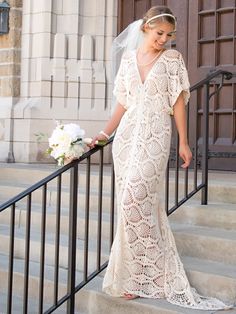 a woman in a wedding dress standing on stairs