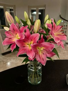 a vase filled with pink flowers sitting on top of a table next to a couch