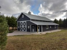 a large gray barn with a clock on the roof