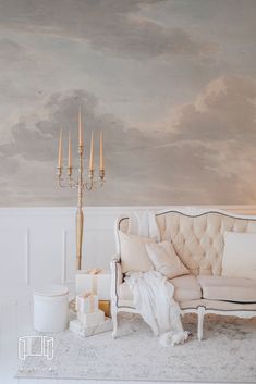 a white couch sitting next to a tall candelabra