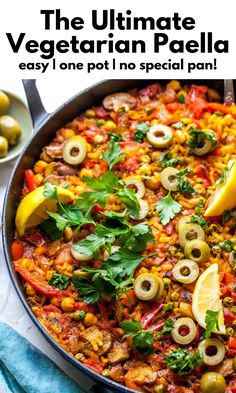 a skillet filled with vegetables and olives on top of a blue towel next to lemon wedges