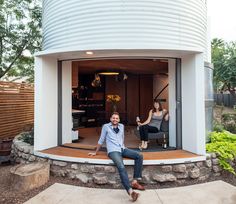 a man sitting on the ground in front of a round house