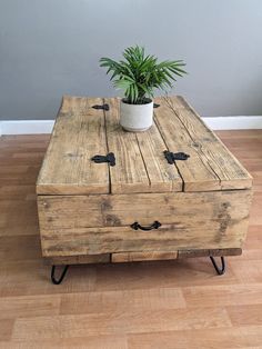 a wooden table with two drawers and a potted plant sitting on top of it