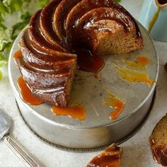 a bundt cake with caramel icing on a plate next to other pastries