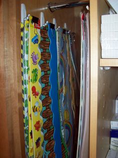 several colorful towels are hanging in a closet