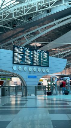 an airport terminal with people waiting for their luggage